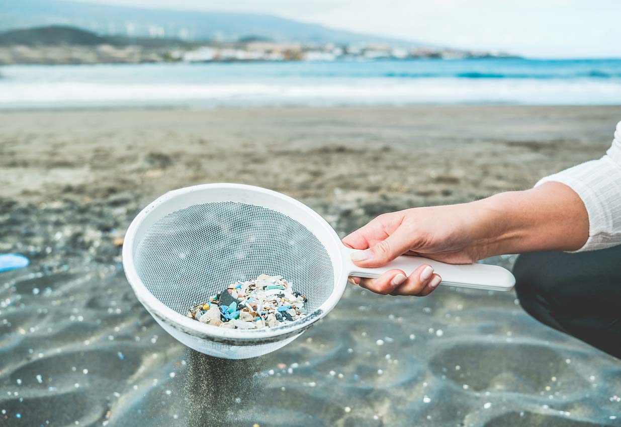 woman cleaning microplastics from sand