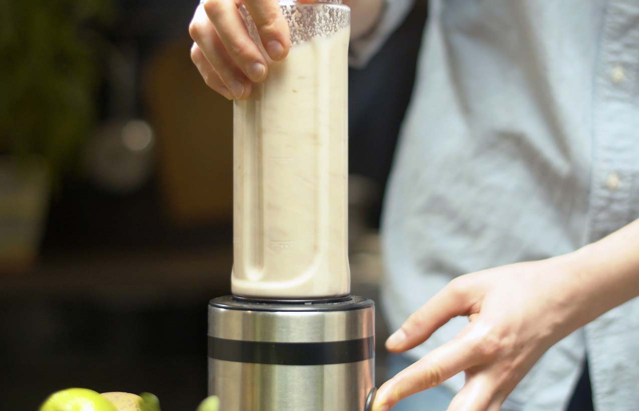Woman making almond milk in a blender