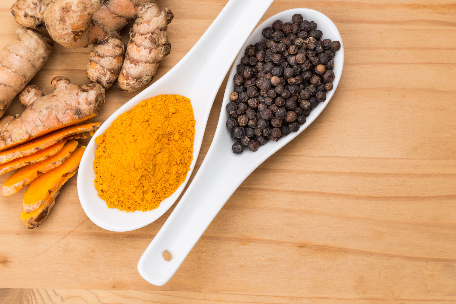 turmeric and black pepper on spoons